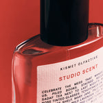 Studio Scent perfume bottle by Kismet Olfactive with a white label on a red background