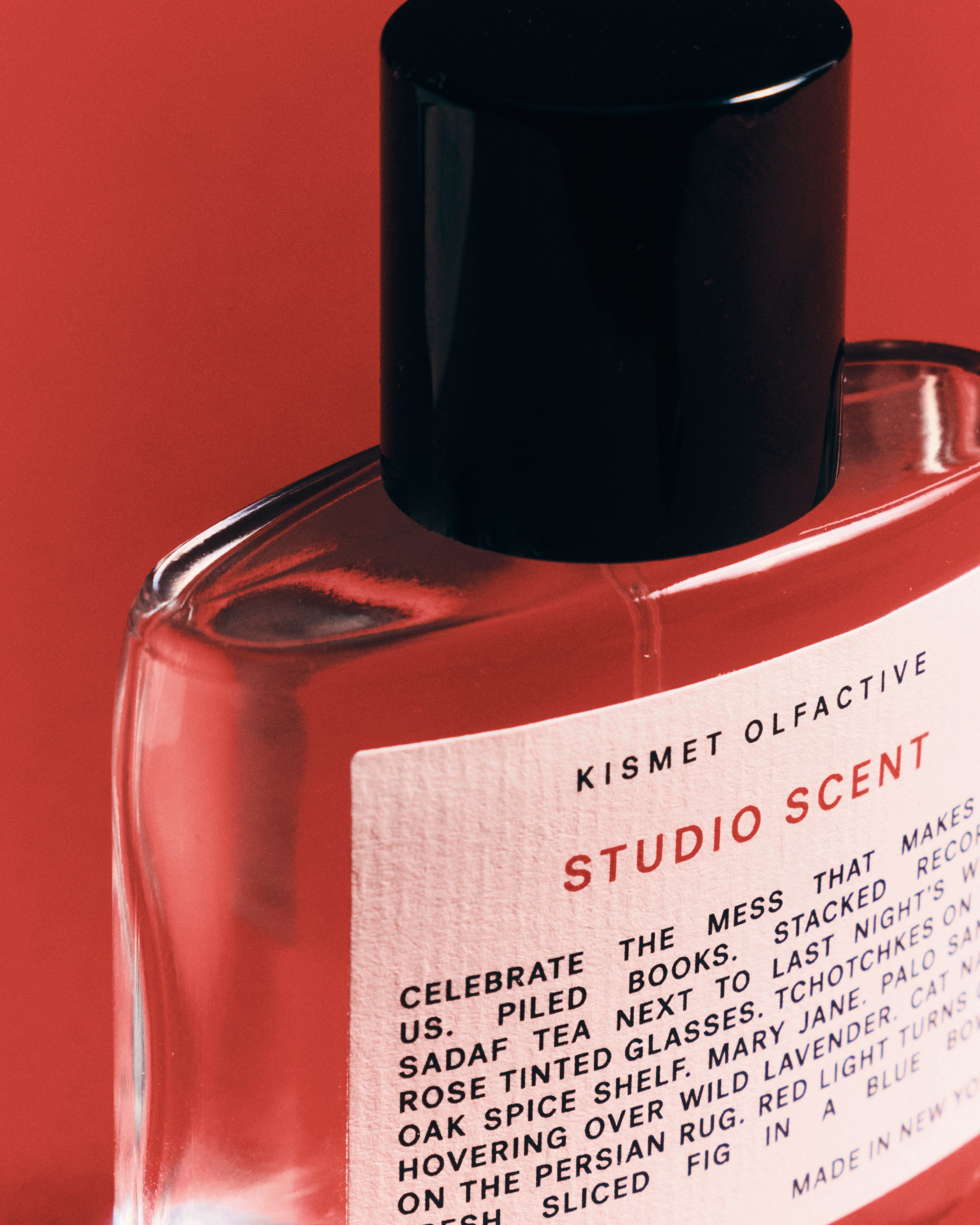 Studio Scent perfume bottle by Kismet Olfactive with a white label on a red background