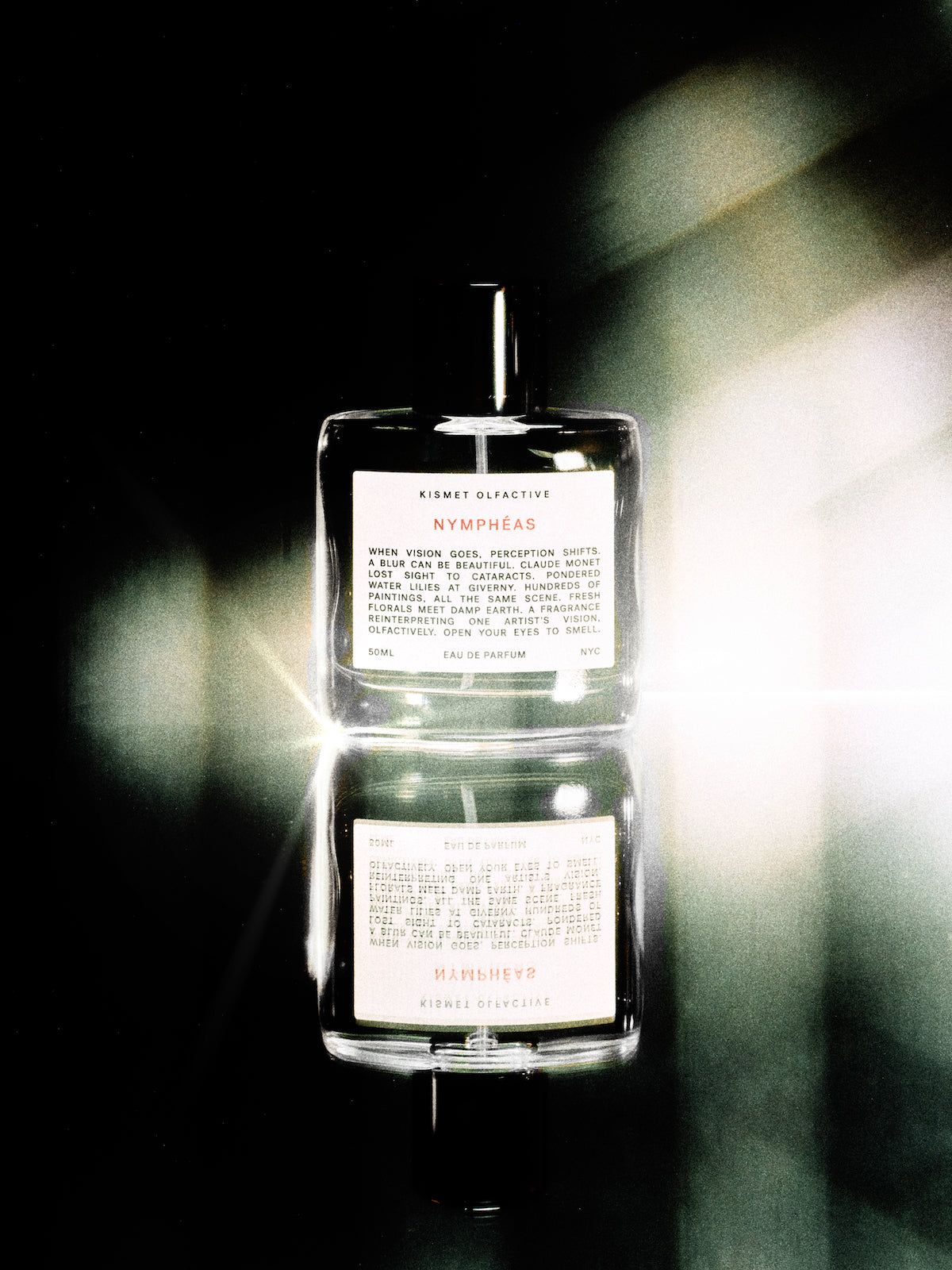 Nymphéas perfume bottle stacked on a dark background with a blurred green leafy plant.