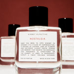 Perfume bottle labeled 'Nostalgia' by Kismet Olfactive with a red background